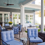 The back porch shows off the gorgeous white columns and blue-gray leader shingles. A brick paver patio completes the look.